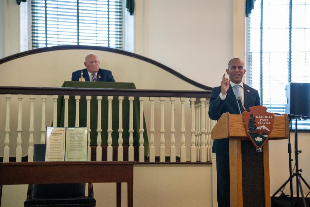 Leader Jeffries speaking from a podium reading "National Park Service"