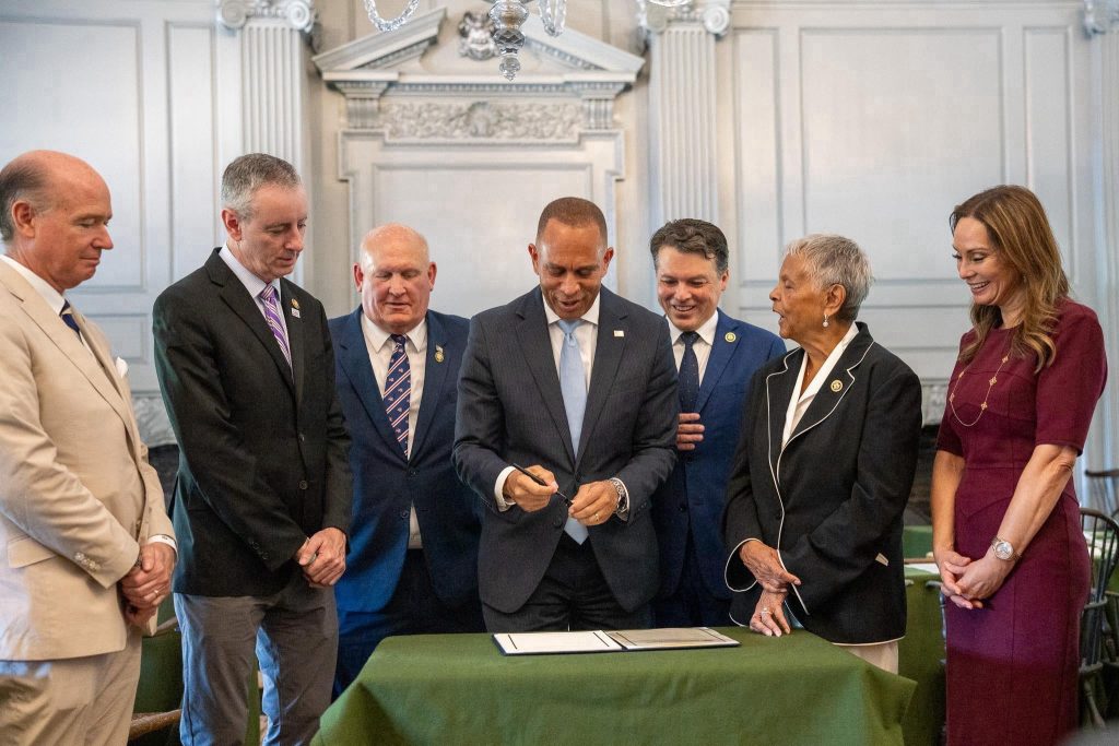Leader Jeffries (center) and Members of the America250 Commission signing CR for inclusion in Congressional Record
